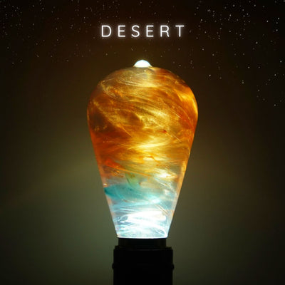 A light bulb with a design resembling a desert landscape, with warm earthy tones and subtle color gradients.
