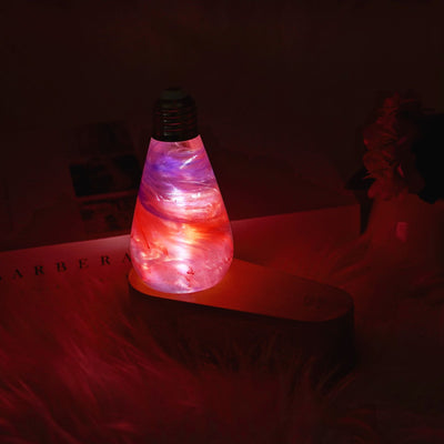 Decorative light bulb with colorful swirling pattern on a dark background